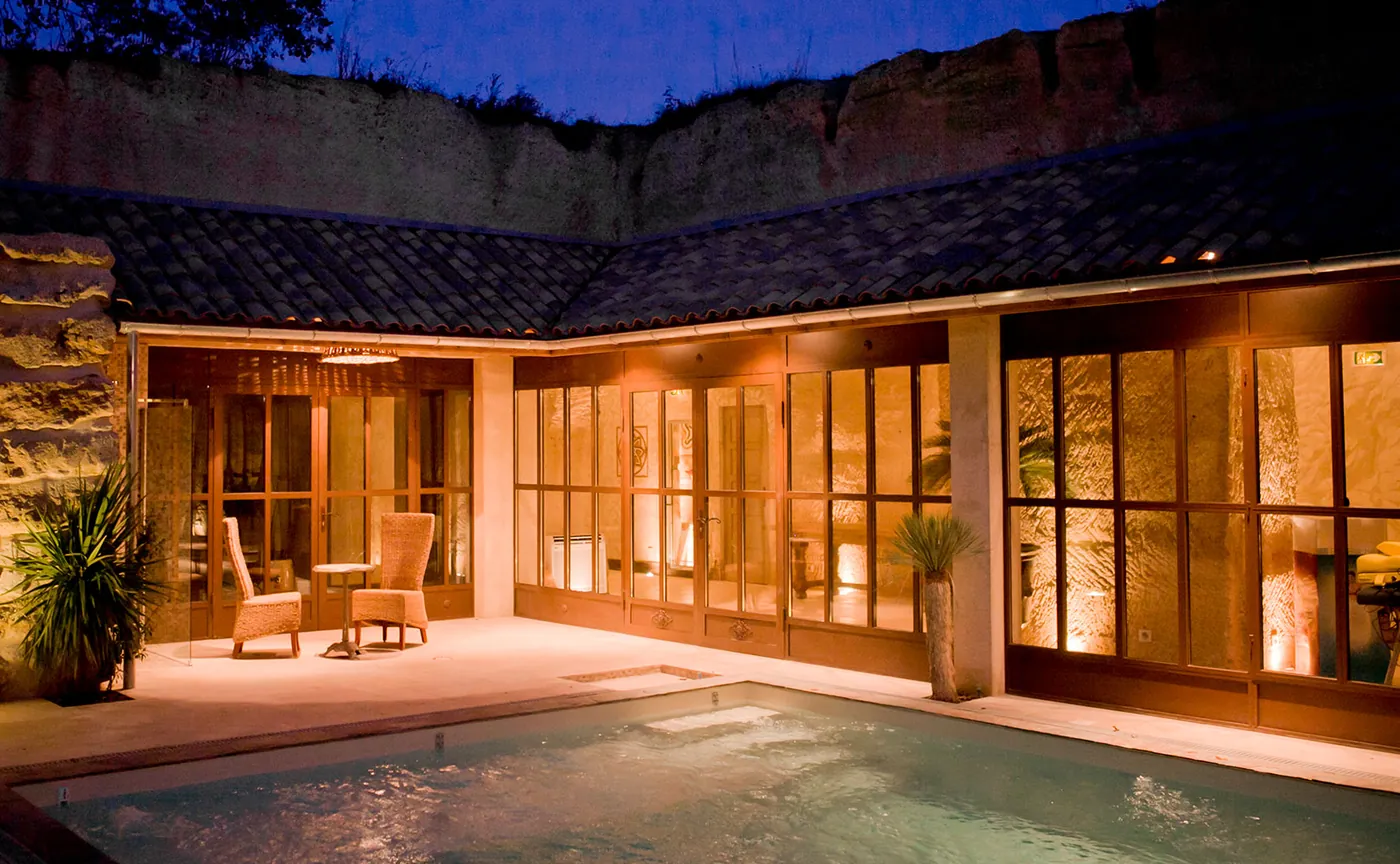 Les terrasses et le bassin du spa illuminés à la nuit tombée